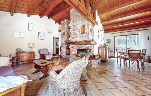 - un salon avec une cheminée en pierre et des chaises dans l'établissement Awesome Home In La Faute Sur Mer, à La Faute-sur-Mer