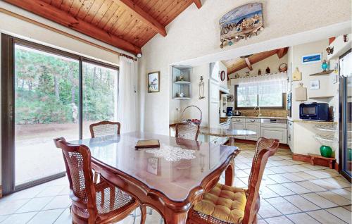 une cuisine avec une table et des chaises ainsi qu'une grande fenêtre dans l'établissement Awesome Home In La Faute Sur Mer, à La Faute-sur-Mer