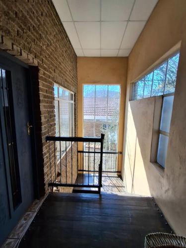 a empty room with a chair in front of a brick wall at The Loft in Bloemfontein
