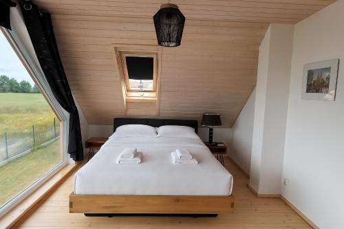 a bedroom with a bed and a large window at Mazurski Relaks in Urowo