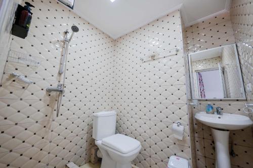a bathroom with a toilet and a sink and a shower at Andy Apartments in Sarandë