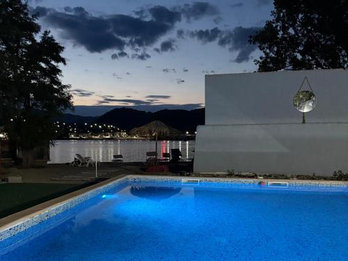a blue swimming pool with a view of the water at CHALET Orsova in Orşova