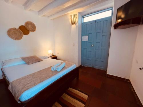 a bedroom with a bed and a blue door at Aura Hotel Parque Barichara By Infinity in Barichara