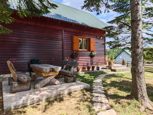 a log cabin with a picnic bench in front of it at Holiday Home Bella in Žabljak