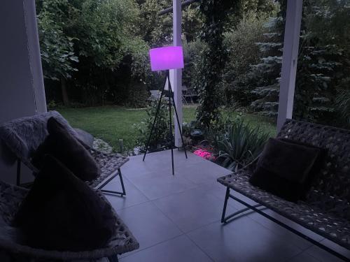 a purple lamp sitting on a porch with two chairs at Haus 16 Ferienhaus zwischen Salzburg Chiemsee und Waging am See in Kirchanschöring