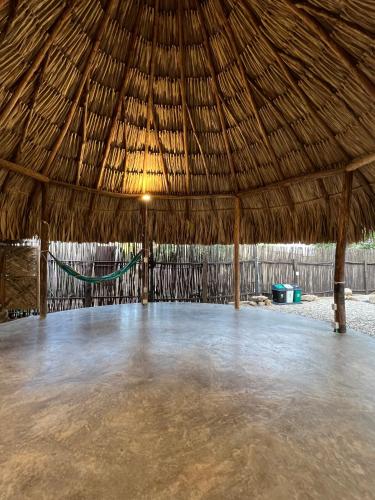 un grand pavillon au toit de paille avec un hamac à l'intérieur dans l'établissement Kogui Aldea, à Palomino