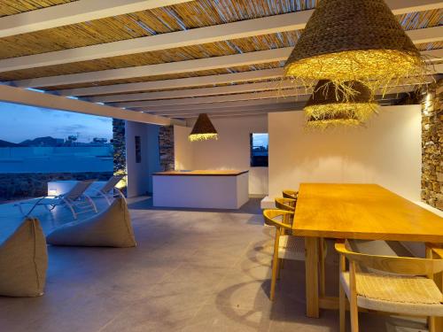 a dining room with a table and chairs at Farous seaside sunset villa in Agios Georgios