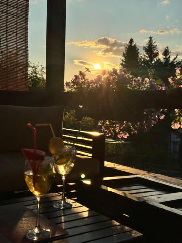 ヴィソコにあるPerla Accommodationの夕日を眺めながらテーブルに置かれた2つのグラスのワイン