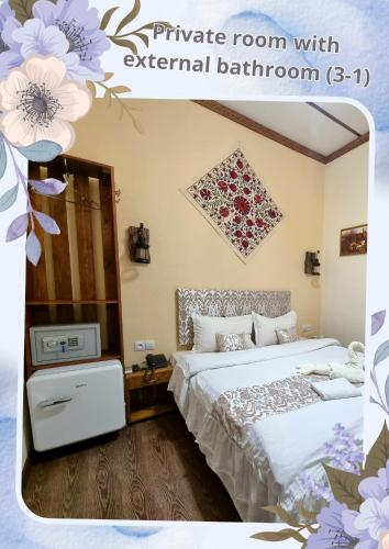 a bedroom with a bed and a tv in it at DRIMIN - by Sunrise Caravan boutique Guesthouse and hostel in Tashkent