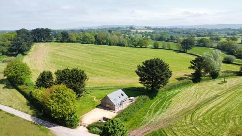 an aerial view of a farmhouse in a field at Deer Den timber clad cabin with hot tub, up private lane in Cullompton