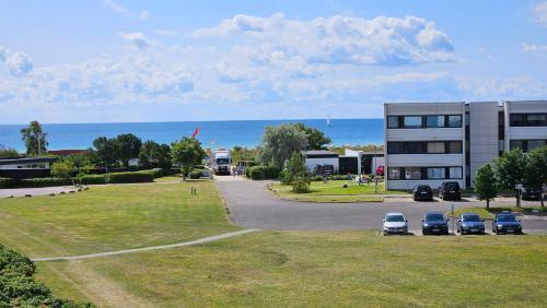 a parking lot with cars parked in front of a building at "Sunny" in Burgtiefe auf Fehmarn 