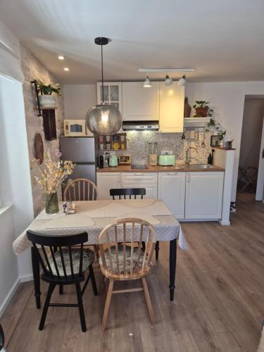 a kitchen with a table and two chairs and a kitchen with white cabinets at Cukarin Heritage in Korčula
