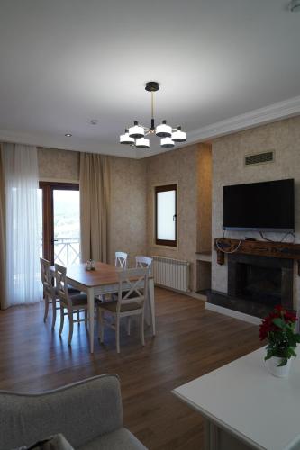 a living room with a table and a fireplace at Green Village HOTEL & SPA in Sis