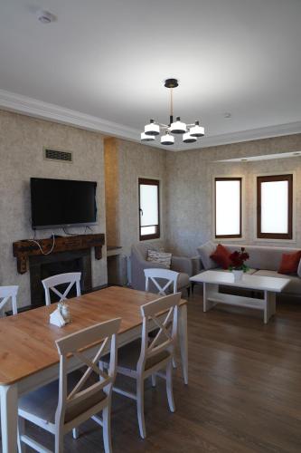 a living room with a table and a couch at Green Village HOTEL & SPA in Sis