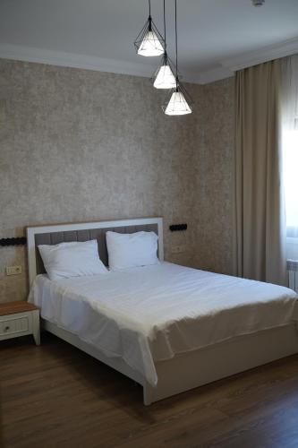 a bedroom with a large white bed with two pillows at Green Village HOTEL & SPA in Sis