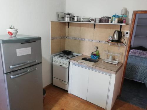 Una pequeña cocina con estufa y refrigerador. en Acuario 2, en Presidencia Roque Sáenz Peña