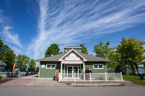 a green building with a white fence in front at The Lynx - 35 Butternut in Cherry Valley