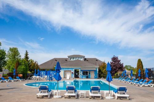 a swimming pool with lounge chairs and umbrellas at The Lynx - 35 Butternut in Cherry Valley