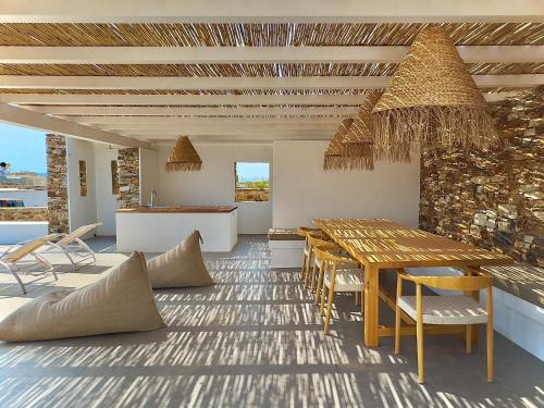 a dining room with a wooden table and chairs at Farous seaside sunset villa in Agios Georgios