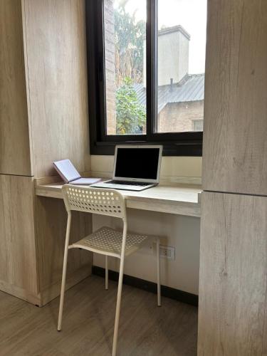 a laptop computer sitting on a desk next to a window at Terroir Village - Complejo de 4 duplex in Guaymallen