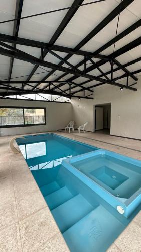 a large swimming pool in a building with a large pool at Terroir Village - Complejo de 4 duplex in Guaymallen