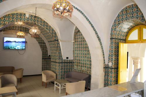 a room with a wall covered in moroccan tiles at Hôtel Medina in Sousse