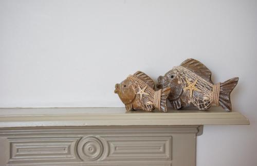 two fish sculptures sitting on top of a fireplace at The Roost in Whitstable