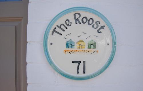 a clock on a wall with a moore roost sign at The Roost in Whitstable