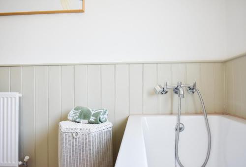 a bathroom with a bath tub with a shower at The Roost in Whitstable