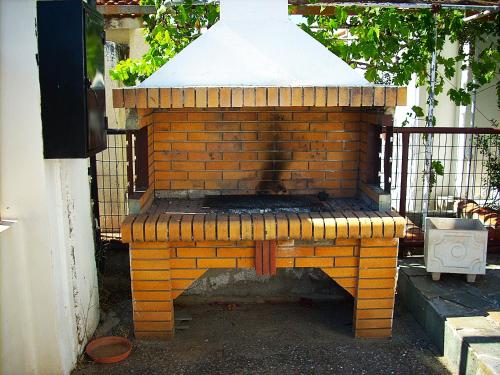 an outdoor brick oven sitting outside of a house at Sea view house II in Dhílesi