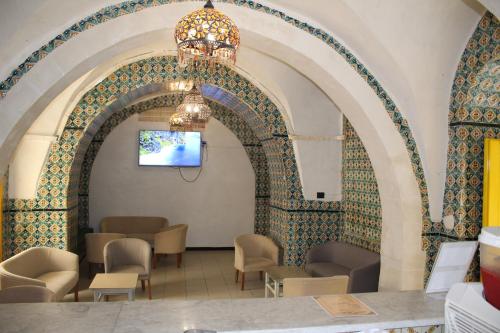 a room with an archway with chairs and a table at Hôtel Medina in Sousse