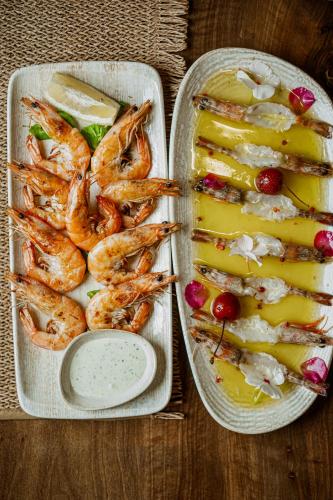 two trays of shrimp and a plate of fruit at Hotel Juza in Borsh