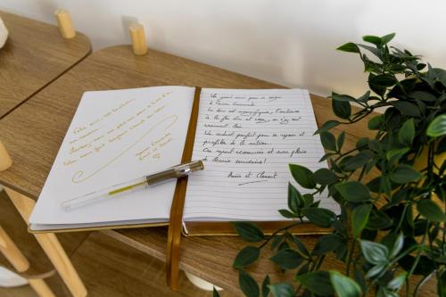 a pen sitting on top of a notebook on a table at Maison Emeraude - Escapade bistrot chic & nature - Proche Vannes in Sérent