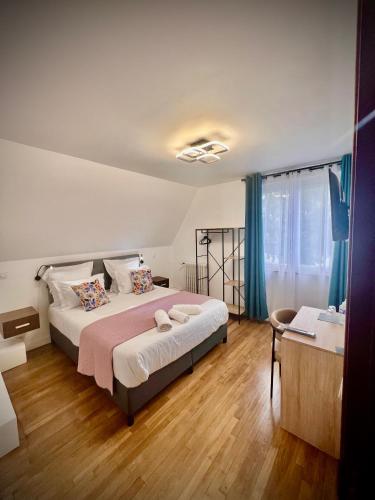 une chambre avec un grand lit avec des rideaux bleus dans l'établissement Les chambres d hôtes de la cassinne, à Montebourg