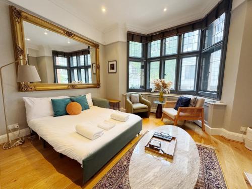 ロンドンにあるStylish Duplex Condo Opposite Hyde Parkのリビングルーム(大型ベッド1台、テーブル付)