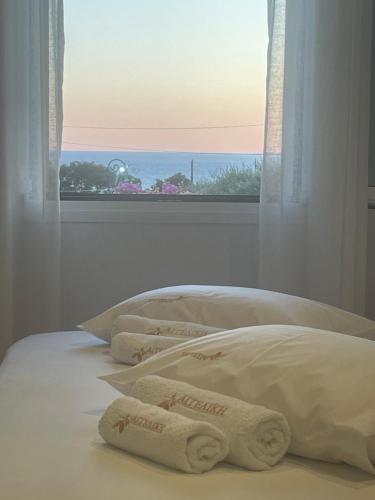 a bedroom with two towels on a bed with a window at Studios Angeliki in Lassi