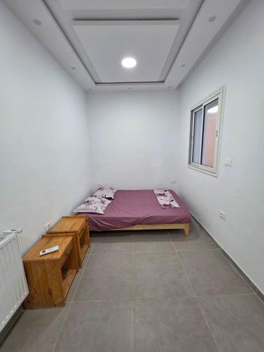 a room with a bed and a table in it at American Style Triplex in Mahdia