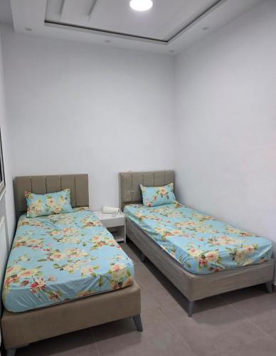 two beds sitting next to each other in a room at American Style Triplex in Mahdia