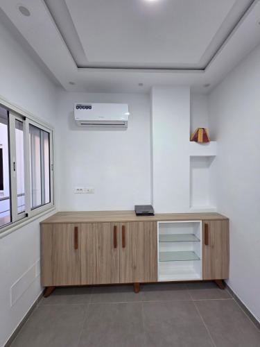 a room with a wooden cabinet and a window at American Style Triplex in Mahdia