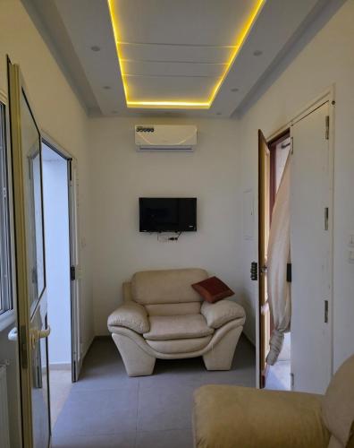 a living room with a couch and a tv at American Style Triplex in Mahdia