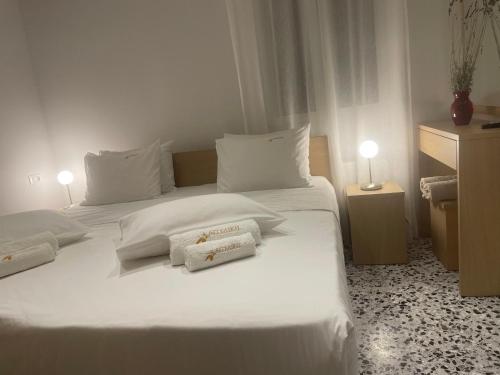 a bedroom with two beds with white sheets and pillows at Studios Angeliki in Lassi