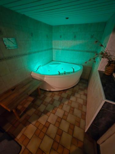 a bath tub in a bathroom with a blue light at Ranna Resort Hostel in Pärnu