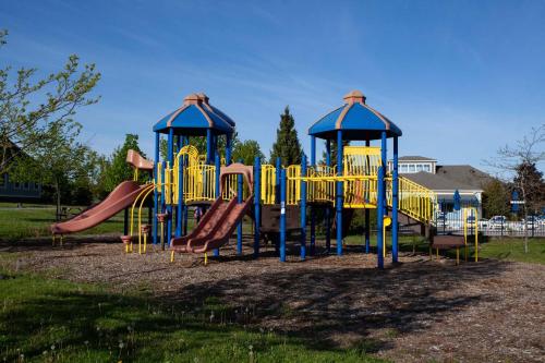 a playground with yellow and blue equipment in a park at The Jackrabbit - 3 Summer Village in Cherry Valley