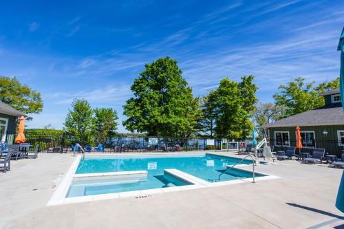 a swimming pool with chairs and trees at The Jackrabbit - 3 Summer Village in Cherry Valley