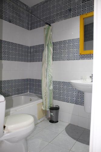 a bathroom with a tub and a toilet and a sink at Hôtel Medina in Sousse