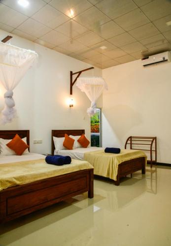 two beds in a room with two beds sidx sidx sidx sidx at EverGreen Resort Udawalawe in Udawalawe