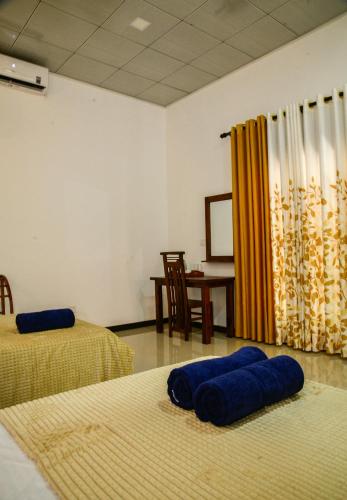 a room with two beds with blue pillows on the floor at EverGreen Resort Udawalawe in Udawalawe