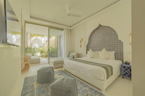 a bedroom with a large bed and a large window at Sana Tulum Beachfront Boutique Hotel in Tulum