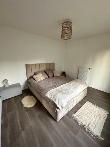 a bedroom with a bed and two rugs on the floor at Love Room Trappes in Trappes