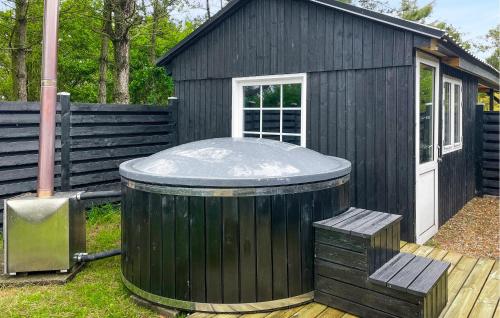 a black shed with a hot tub in front of it at 4 Bedroom Lovely Home In Vestervig in Vestervig